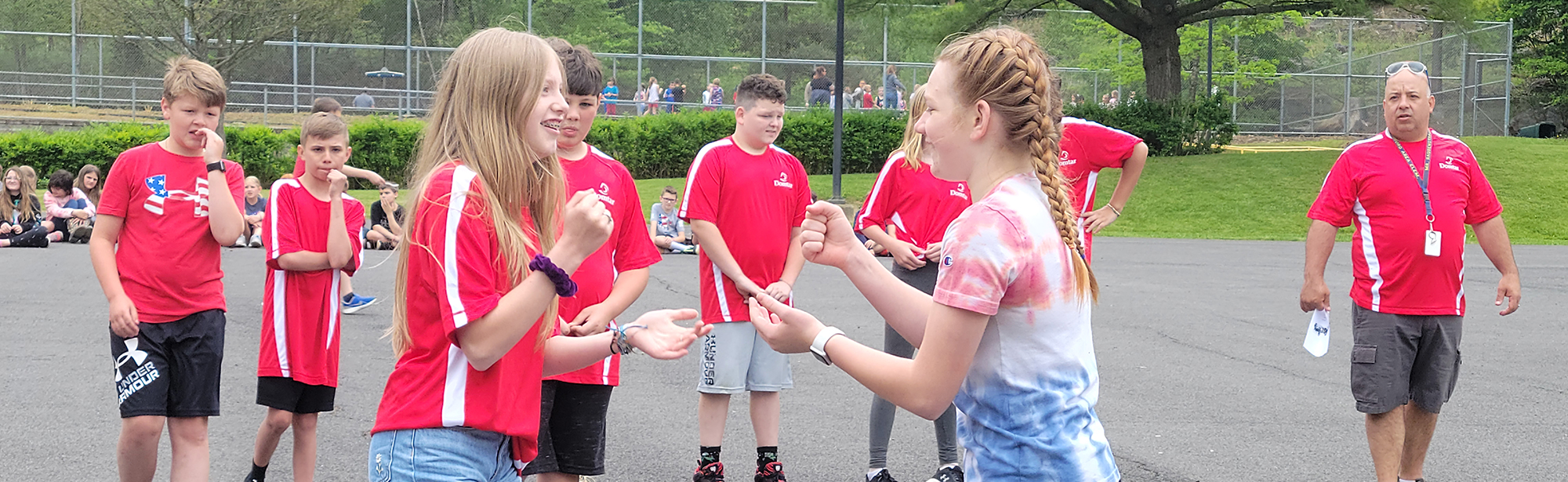 elementary students playing a hand clapping game at field day