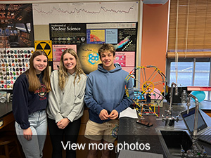 Three students beside small K'nex ferris wheel in science room