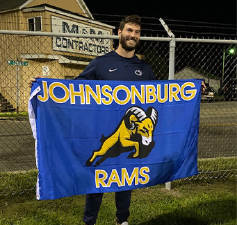 Athlete holding Johnsonburg Rams flag