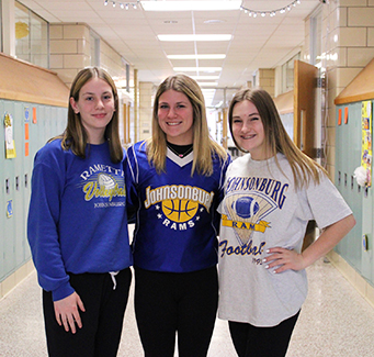 Three happy high school girls in the school hallway
