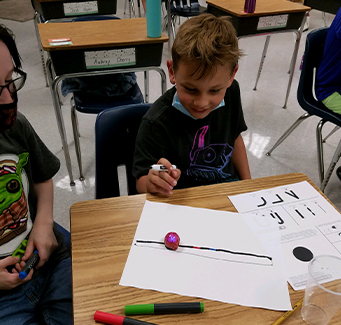 Two elementary students working on group assignment
